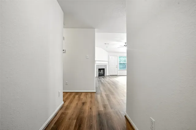 a view of a room with wooden floor and a hallway