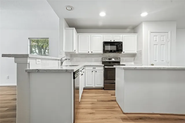 a kitchen with a stove a sink and a microwave
