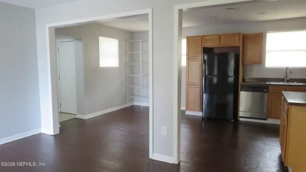 a view of a hallway with wooden floor and a window