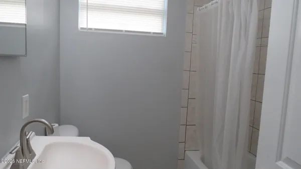 a bathroom with a toilet sink and window