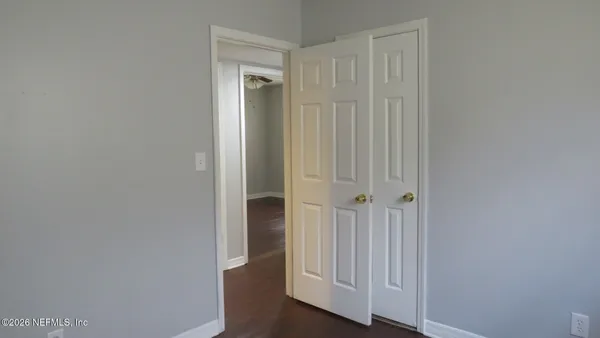 a view of a hallway with wooden floor