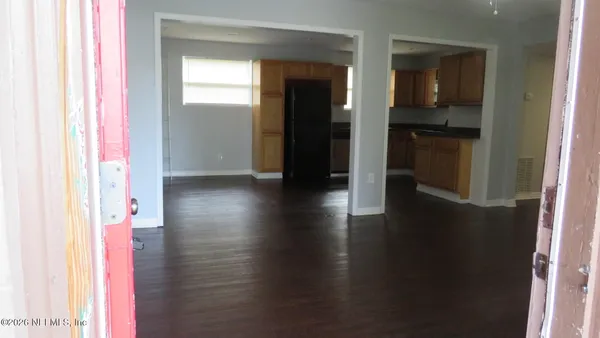 a view of a hallway with wooden floor and a cabinet