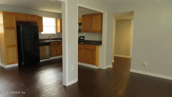 a kitchen with a refrigerator and wooden floor