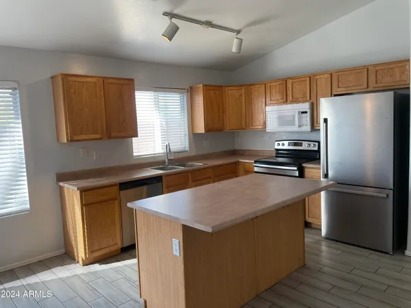 a kitchen with wooden cabinets and stainless steel appliances