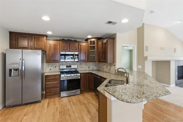 a kitchen with stainless steel appliances granite countertop a sink stove and refrigerator