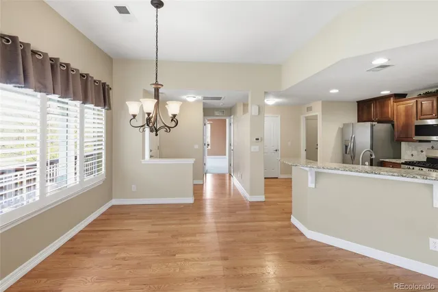 a view of an empty room with chandelier fan