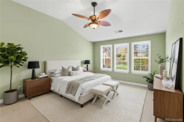an empty room with chandelier fan and windows