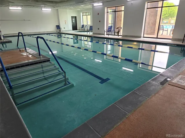 a living room with furniture gym equipment and large windows