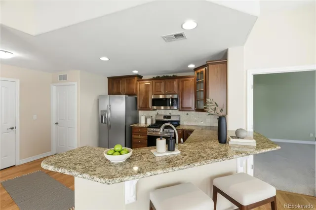 a kitchen with stainless steel appliances granite countertop a refrigerator sink and stove
