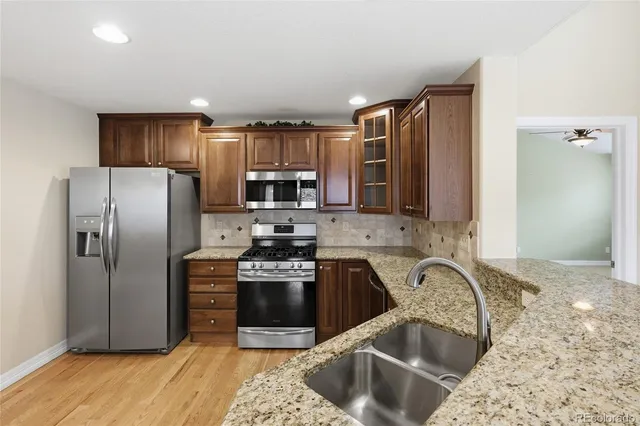 a kitchen with stainless steel appliances granite countertop a sink stove and refrigerator