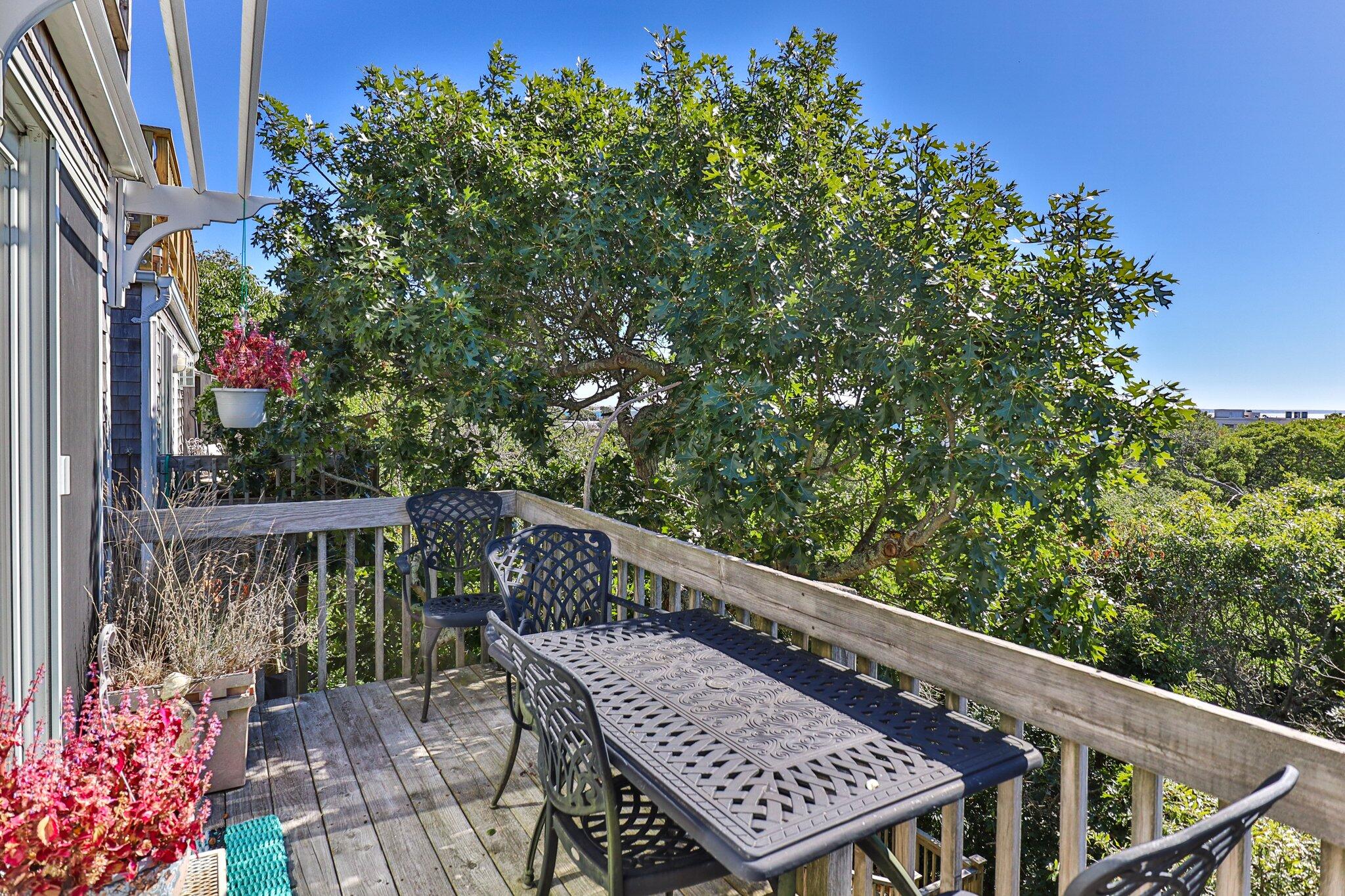4 Willow Drive, Unit 9 Provincetown, MA 02657 - Photo 3 of 25 a balcony with wooden floor and outdoor seating