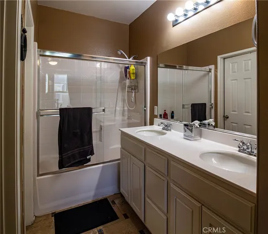 a bathroom with a double vanity sink a mirror and shower