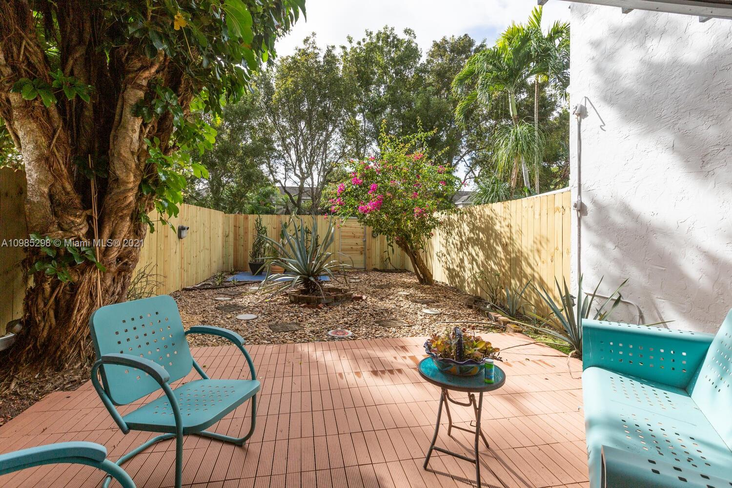 7028 Southwest 53rd Lane Miami, FL 33155 - Photo 17 of 27 a view of a backyard with table and chairs potted plants and large tree