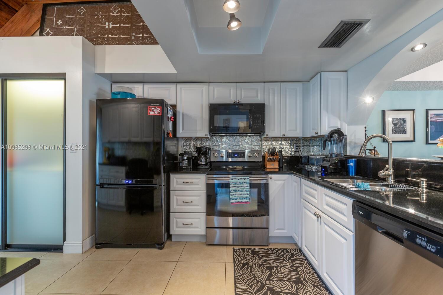 7028 Southwest 53rd Lane Miami, FL 33155 - Photo 5 of 27 a kitchen with a refrigerator and a sink