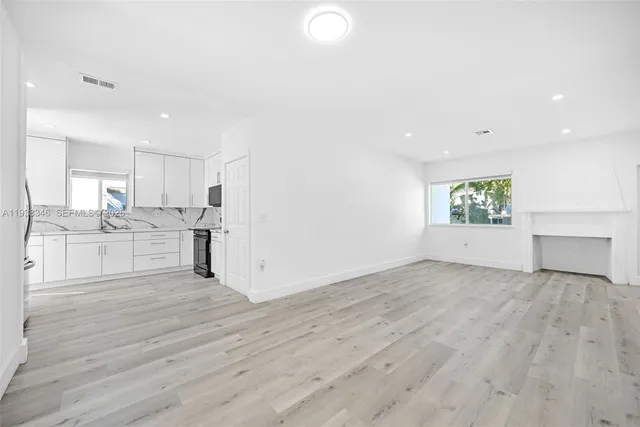 a kitchen with granite countertop white cabinets stainless steel appliances and sink