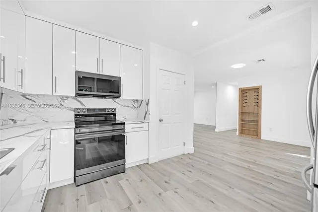 a kitchen with granite countertop white cabinets and sink