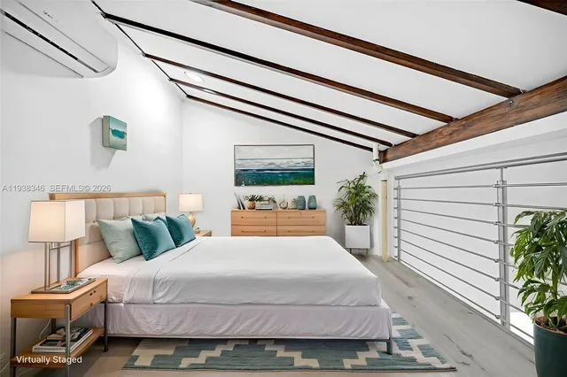 a view of a white house with a small yard plants and a large tree