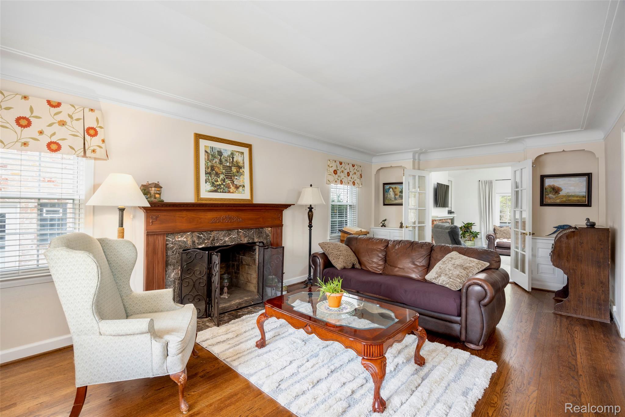 244 Kerby Road Grosse Pointe, MI 48236 - Photo 11 of 53 Living area featuring wood finished floors, a high end fireplace, crown molding, and arched walkways