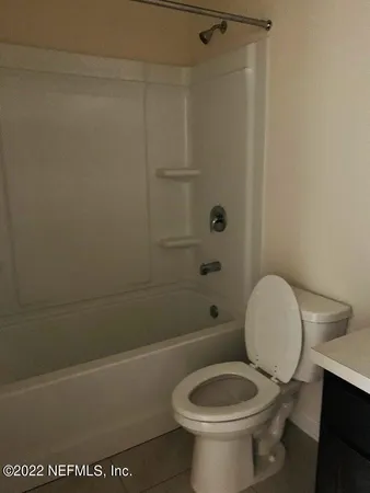 a white toilet sitting next to a bath tub and a shower