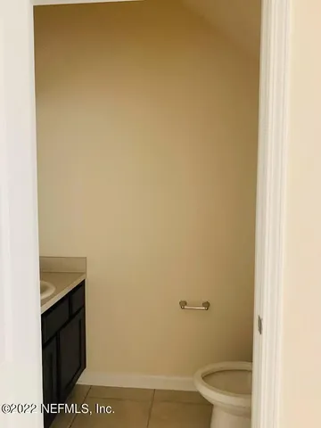 a bathroom with a granite countertop toilet and a sink
