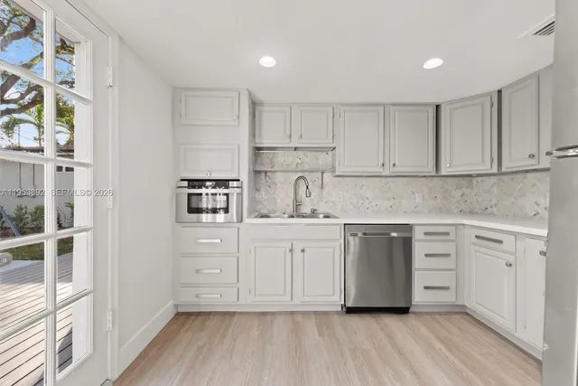 a kitchen with stainless steel appliances granite countertop a stove and white cabinets