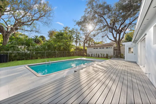 a view of backyard with swimming pool and outdoor seating