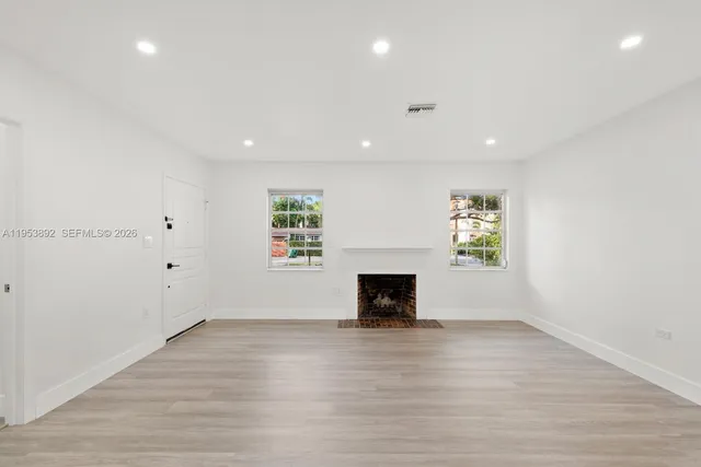 an empty room with a fireplace and window