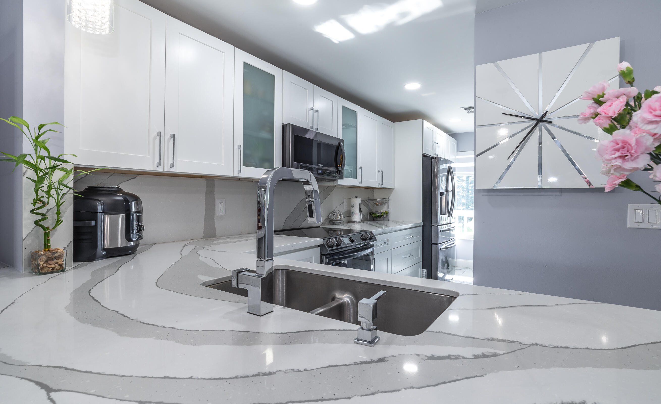 2915 Southwest 15th Street, Unit 203 Delray Beach, FL 33445 - Photo 14 of 48 a kitchen with stainless steel appliances kitchen island granite countertop a sink a stove and a microwave