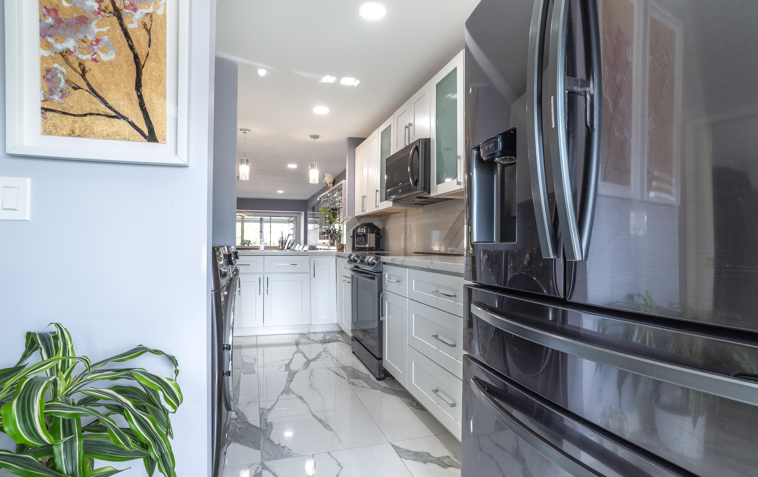 2915 Southwest 15th Street, Unit 203 Delray Beach, FL 33445 - Photo 20 of 48 a kitchen with stainless steel appliances a refrigerator and a counter top space