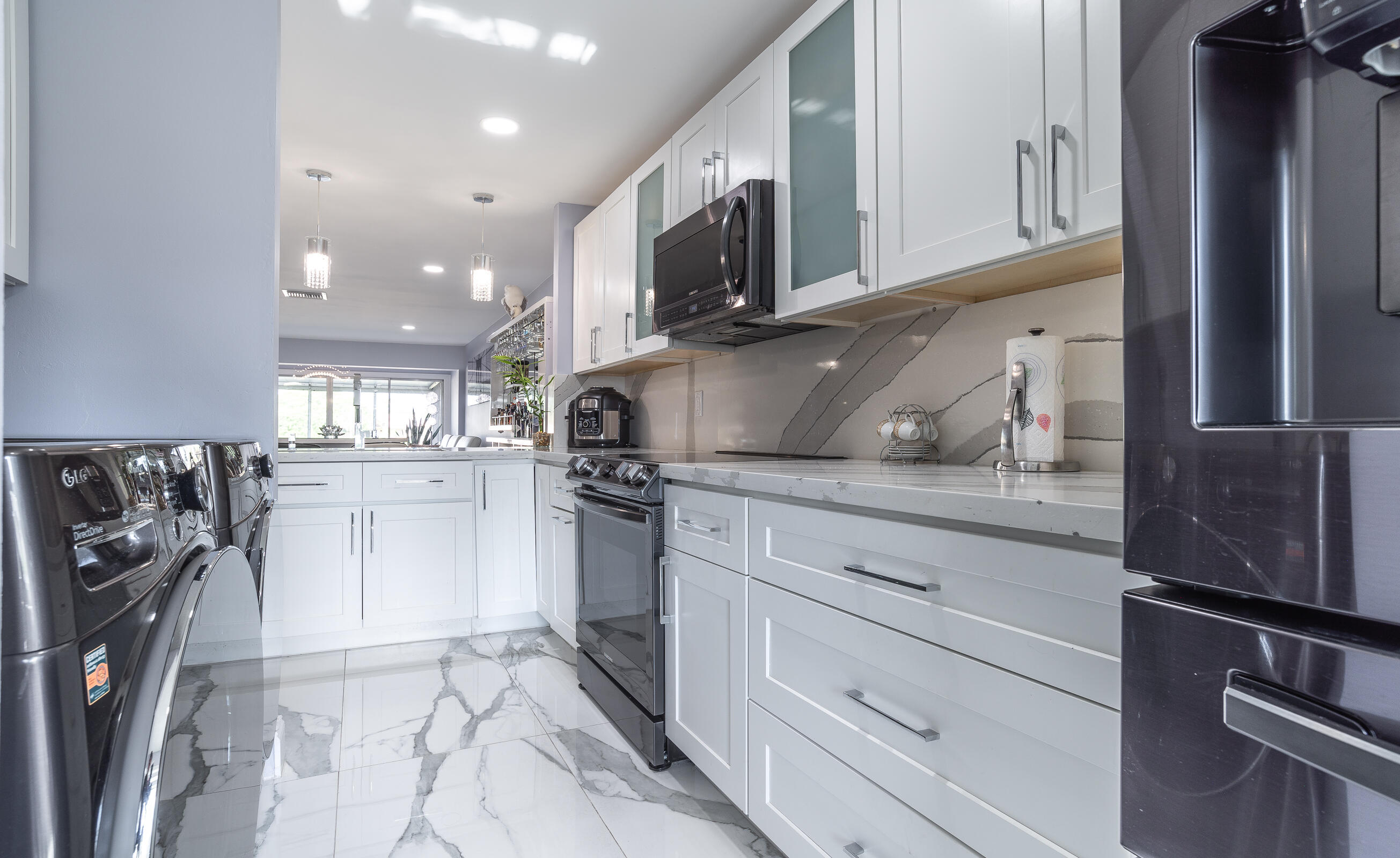 2915 Southwest 15th Street, Unit 203 Delray Beach, FL 33445 - Photo 21 of 48 a kitchen with stainless steel appliances granite countertop a refrigerator and a stove top oven