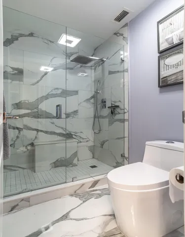 a white toilet sitting next to a bath tub and shower