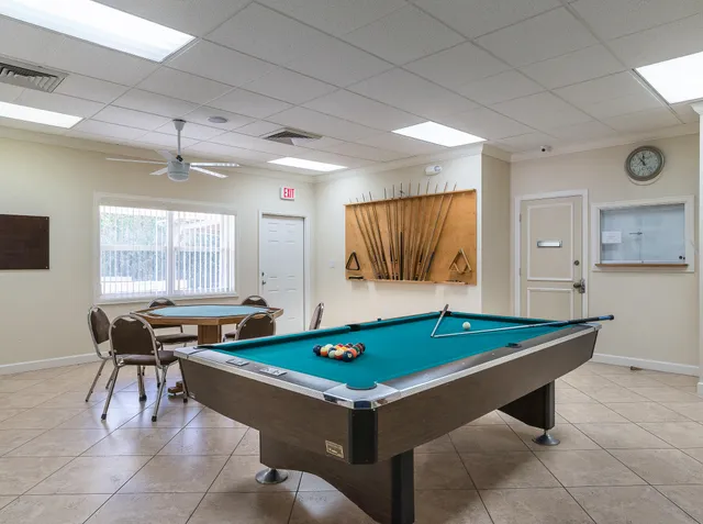 a room with pool table and windows