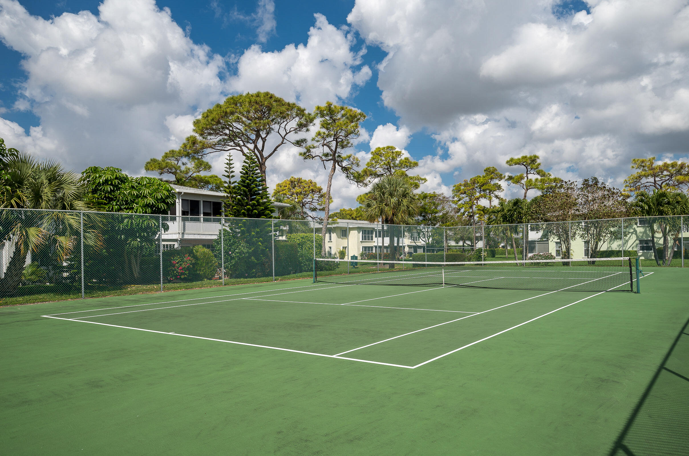 2915 Southwest 15th Street, Unit 203 Delray Beach, FL 33445 - Photo 41 of 48 a view of a tennis ground with large trees