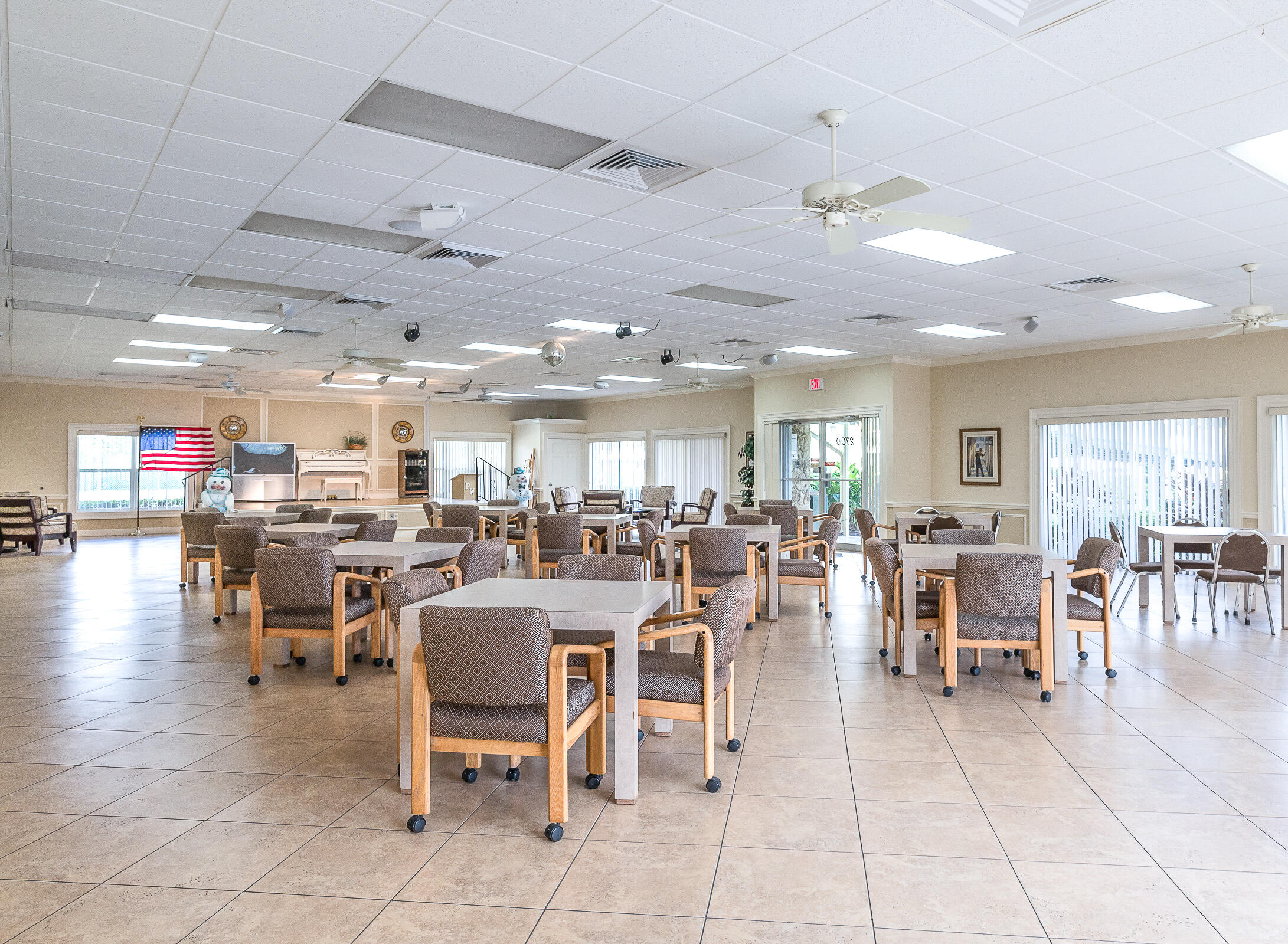 2915 Southwest 15th Street, Unit 203 Delray Beach, FL 33445 - Photo 47 of 48 a room with lots of tables a large window and chairs