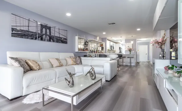 a living room with furniture and a dining table with kitchen view