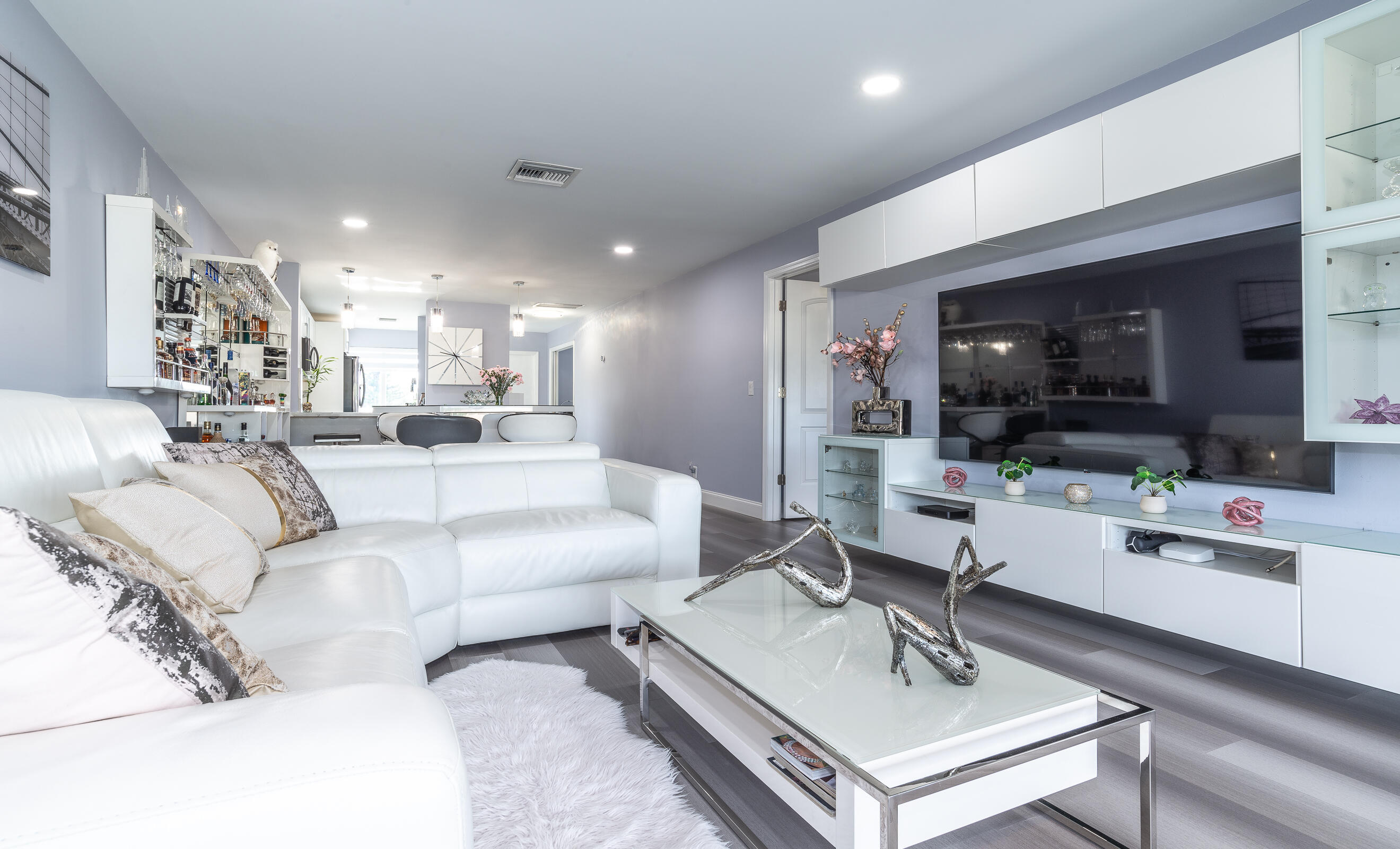 2915 Southwest 15th Street, Unit 203 Delray Beach, FL 33445 - Photo 10 of 48 a living room with furniture a flat screen tv and kitchen view