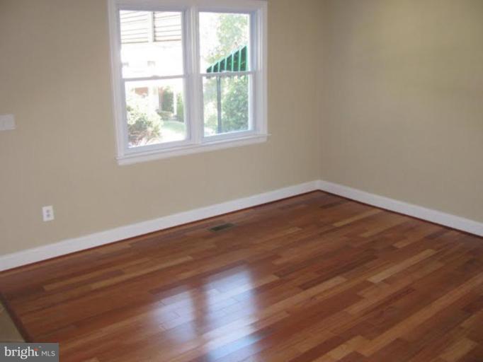 1011 Andover Road Baltimore, MD 21218 - Photo 3 of 29 an empty room with wooden floor and windows