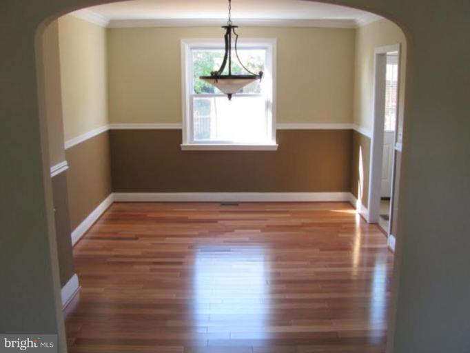 1011 Andover Road Baltimore, MD 21218 - Photo 4 of 29 a view of empty room with wooden floor and fan