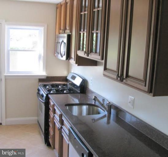 1011 Andover Road Baltimore, MD 21218 - Photo 6 of 29 a kitchen with granite countertop a sink and a stove top oven