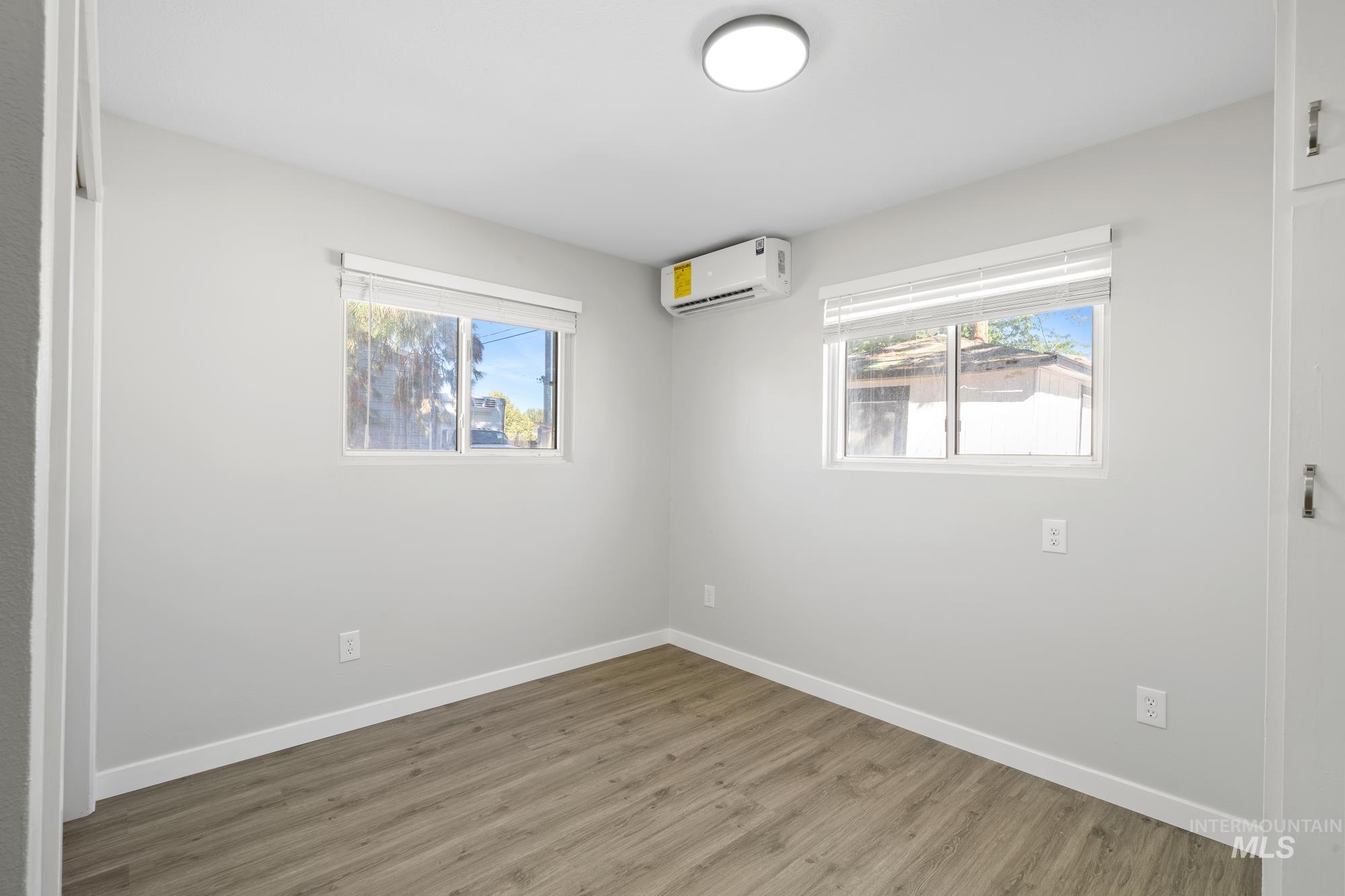 716 West Linden Street Boise, ID 83706 - Photo 34 of 47 Empty room featuring wood finished floors and a wall mounted AC