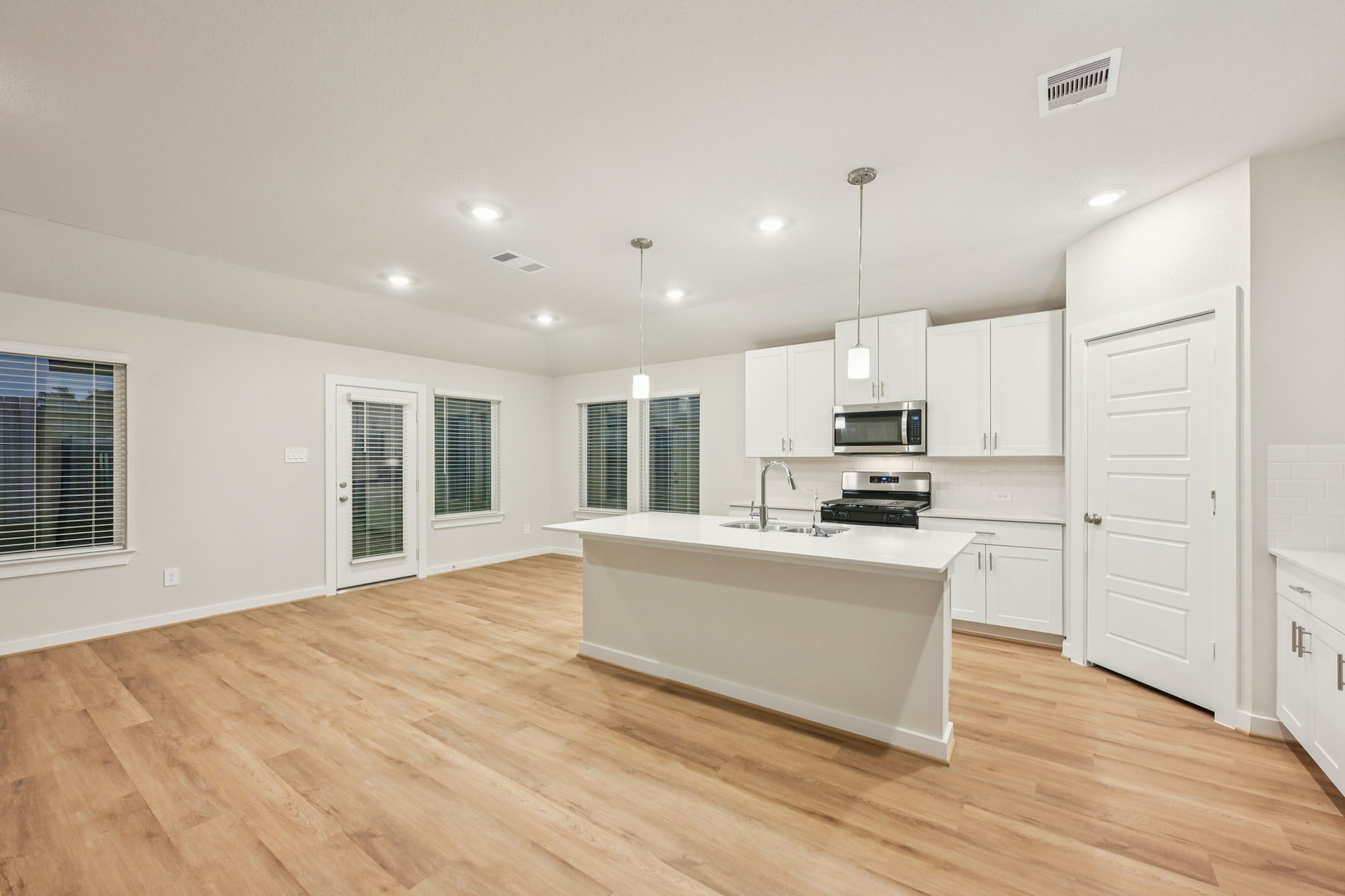 1637 Hopson Ranch Drive Conroe, TX 77301 - Photo 7 of 39 a kitchen with stainless steel appliances granite countertop a stove top oven a sink dishwasher a refrigerator and white cabinets with wooden floor