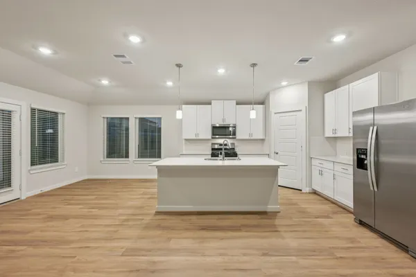 a view of kitchen with stainless steel appliances refrigerator stove microwave and cabinets