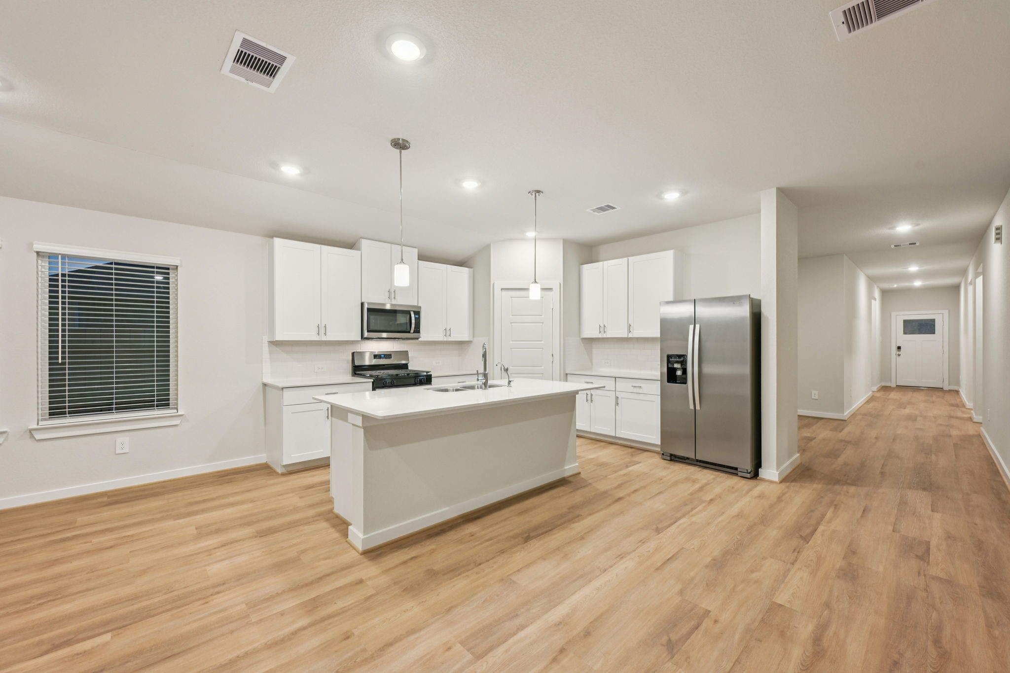 1637 Hopson Ranch Drive Conroe, TX 77301 - Photo 9 of 39 a large kitchen with stainless steel appliances kitchen island a large counter top and a wooden floors