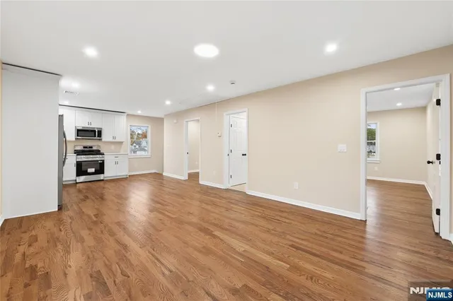 a view of empty room with wooden floor