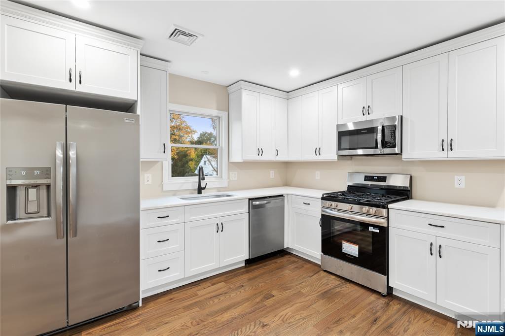 937 Ringwood Avenue, Unit 2 Wanaque, NJ 07420 - Photo 4 of 11 a kitchen with stainless steel appliances granite countertop a stove a sink and a refrigerator