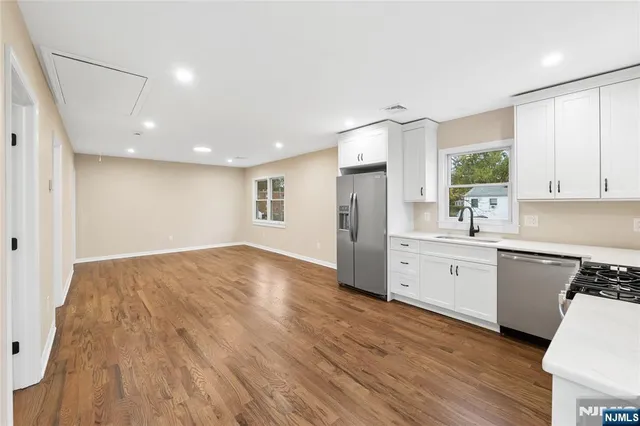 a large kitchen with kitchen island a sink stainless steel appliances and cabinets
