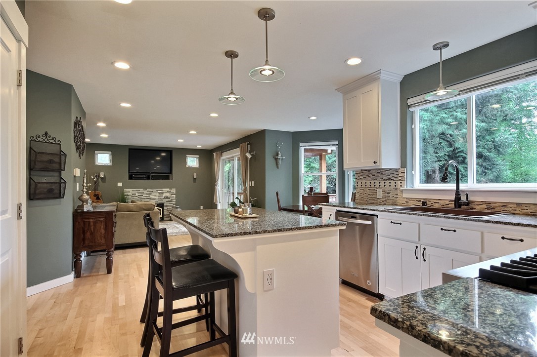 4706 224th Street Southeast Bothell, WA 98021 - Photo 11 of 38 a kitchen with stainless steel appliances granite countertop table chairs sink and cabinets