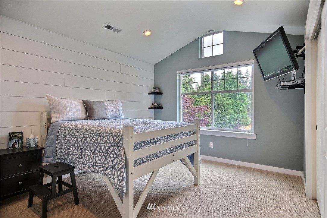 4706 224th Street Southeast Bothell, WA 98021 - Photo 21 of 38 a bedroom with a bed and a flat tv screen on the dresser