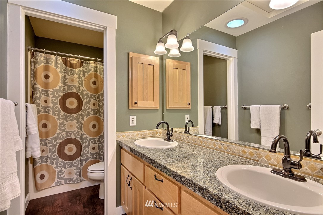 4706 224th Street Southeast Bothell, WA 98021 - Photo 23 of 38 a bathroom with a granite countertop sink and a mirror