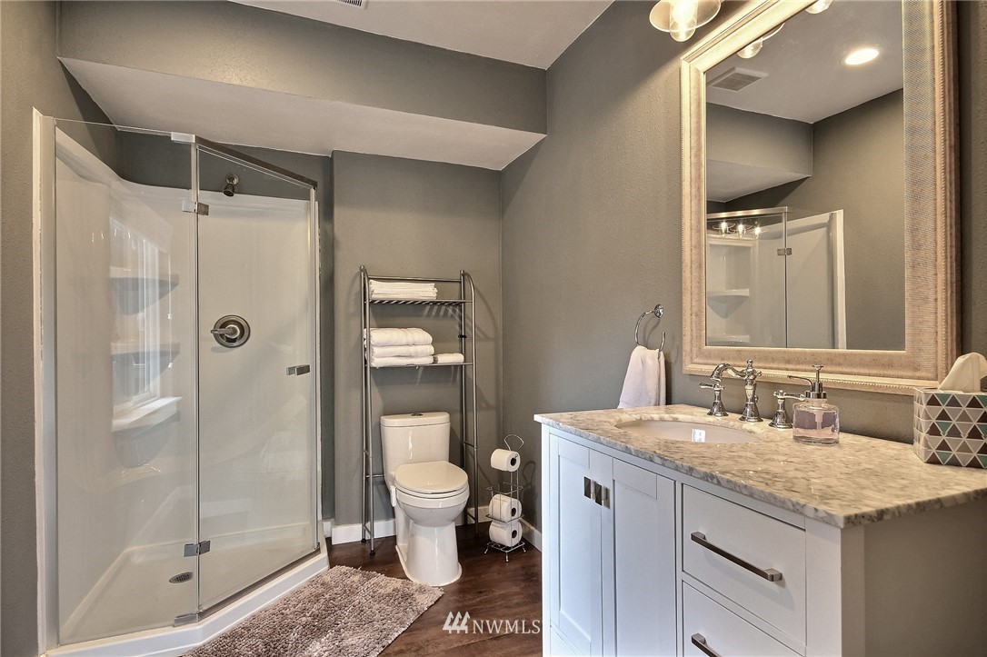 4706 224th Street Southeast Bothell, WA 98021 - Photo 25 of 38 a bathroom with a granite countertop sink a toilet and shower